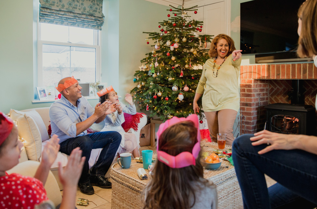 stock image of family playing games in their living room in front of a christmas tree